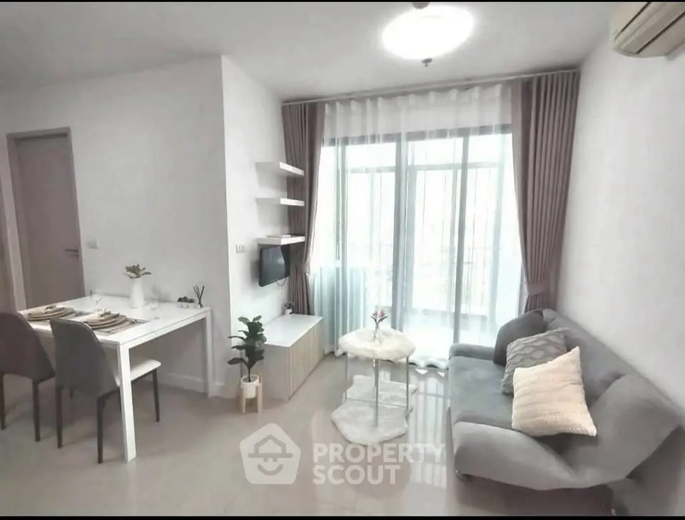 Modern living room with cozy sofa, dining area, and large window for natural light.