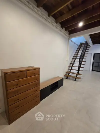 Spacious modern interior with wooden ceiling and staircase, perfect for stylish living.