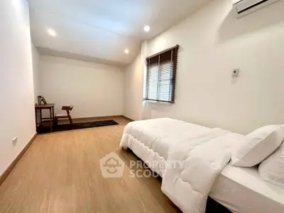 Spacious minimalist bedroom with wooden flooring and cozy ambiance