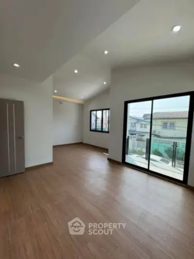 Spacious modern living room with large windows and wooden flooring