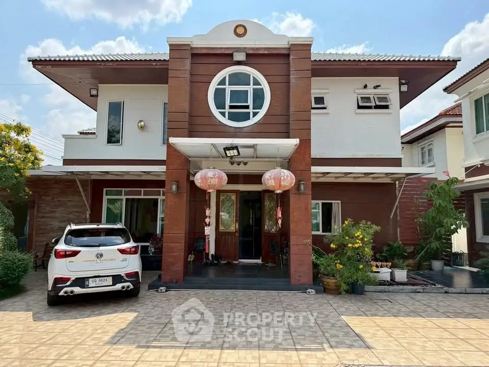 Charming two-story house with unique circular window and spacious driveway.
