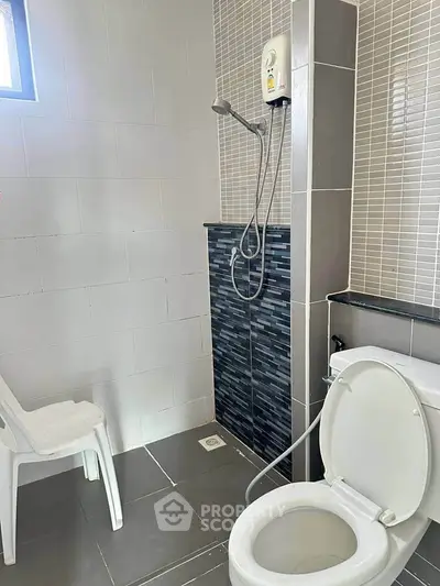 Modern bathroom with shower and toilet in a minimalist design.