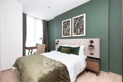Modern bedroom with green accent wall and stylish decor