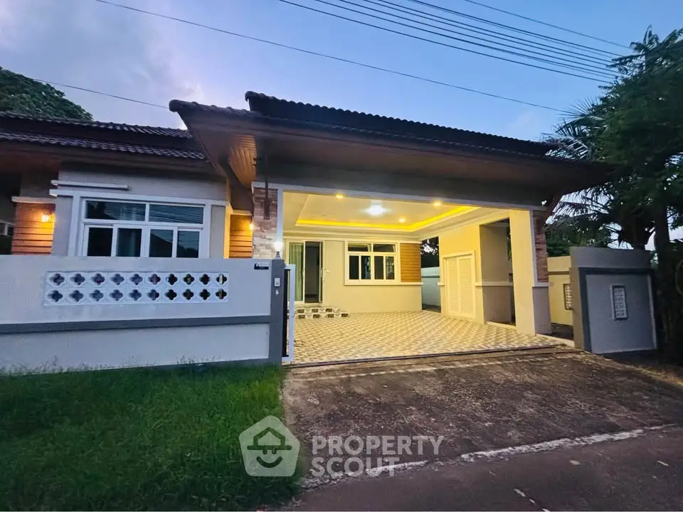Charming single-story home with spacious driveway and modern exterior lighting, perfect for family living.