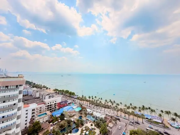 Stunning ocean view from high-rise building overlooking beach and cityscape, perfect for luxury living.