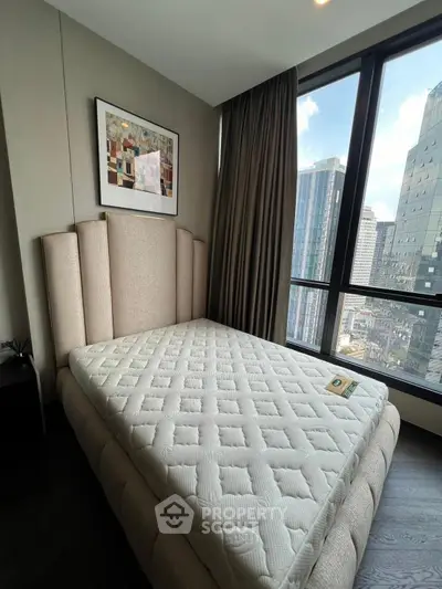 Luxurious bedroom with city view and elegant decor in modern apartment.