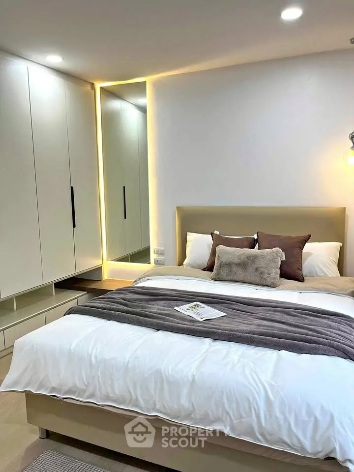 Modern bedroom with cozy bed and stylish wardrobe featuring ambient lighting.