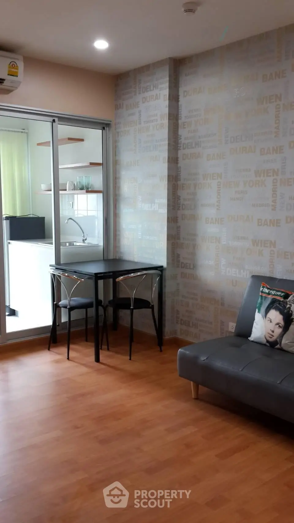Modern living room with stylish decor and open kitchen layout, featuring sleek furniture and wooden flooring.