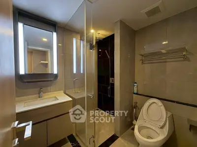Modern bathroom with sleek design, featuring a glass shower enclosure and elegant fixtures.
