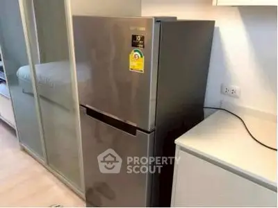 Modern kitchen with sleek stainless steel refrigerator and ample storage space.