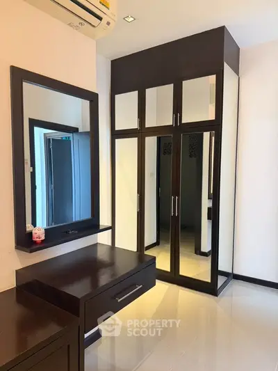 Modern bedroom with mirrored wardrobe and sleek dressing table