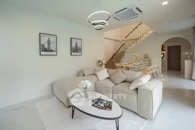 Modern living room with elegant decor and open layout, featuring a cozy sofa and stylish lighting.