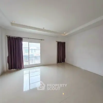 Spacious empty living room with large windows and elegant curtains