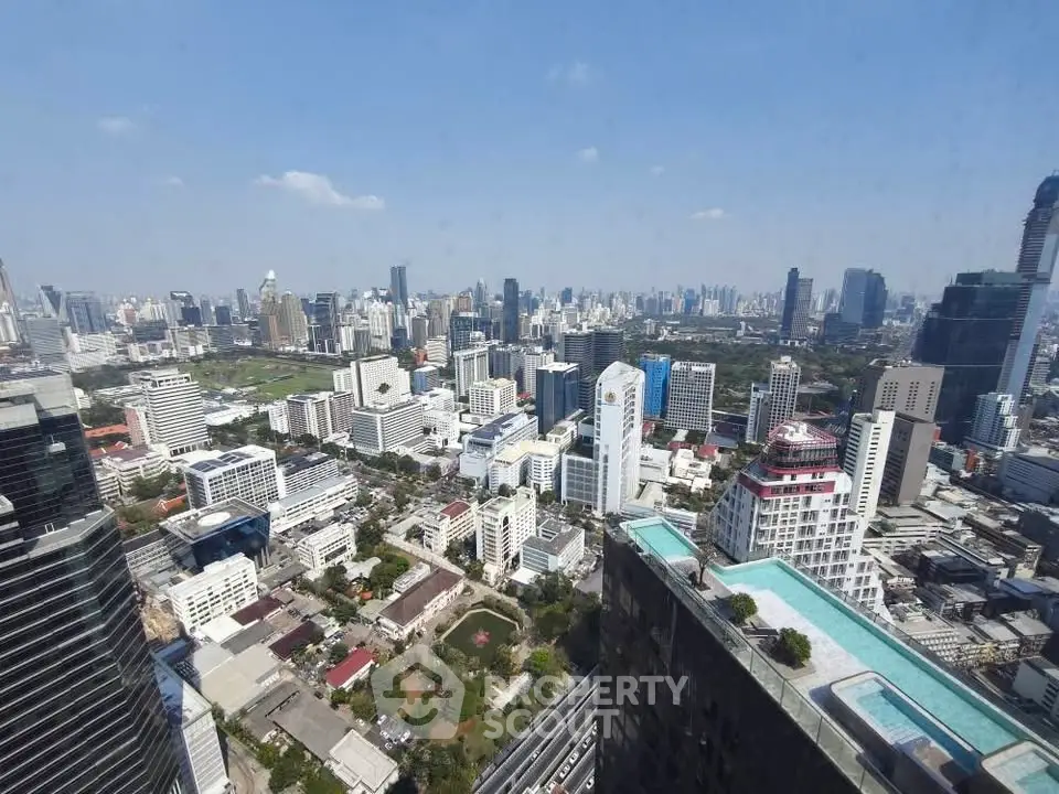 Stunning cityscape view from a high-rise building with a rooftop pool, showcasing urban living at its finest.