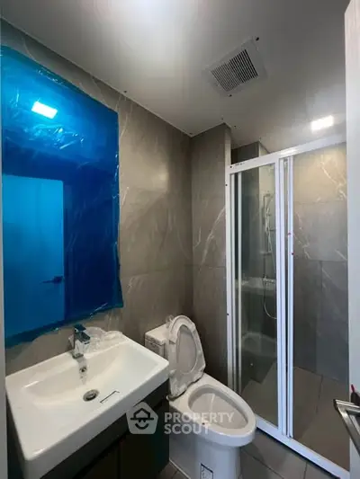 Modern bathroom with sleek shower and stylish fixtures in contemporary apartment.