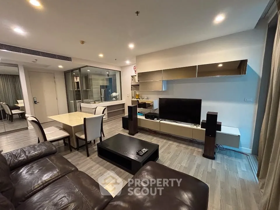 Modern living room with sleek furniture and open layout, featuring a cozy seating area and stylish dining space.