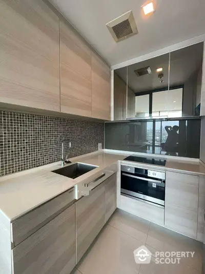 Modern kitchen with sleek cabinetry and built-in appliances in a high-rise apartment.