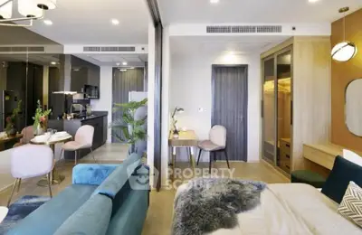 Modern open-plan living room and kitchen with stylish decor and cozy bedroom area.