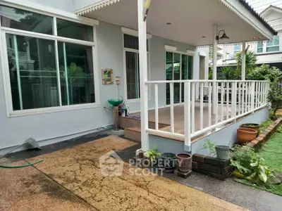 Charming house exterior with spacious porch and lush garden view