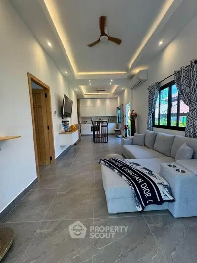 Spacious modern living room with elegant decor and large windows offering natural light.