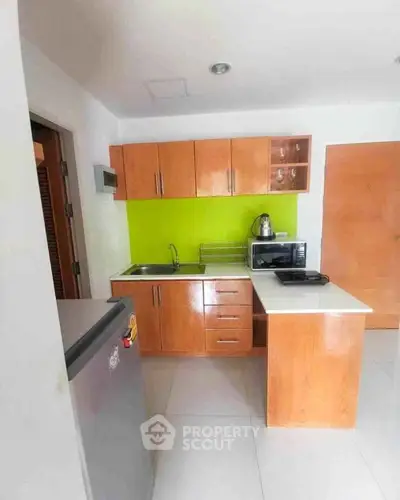 Modern kitchen with vibrant green backsplash and wooden cabinetry