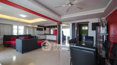 Spacious modern living room with open kitchen and stylish red accents