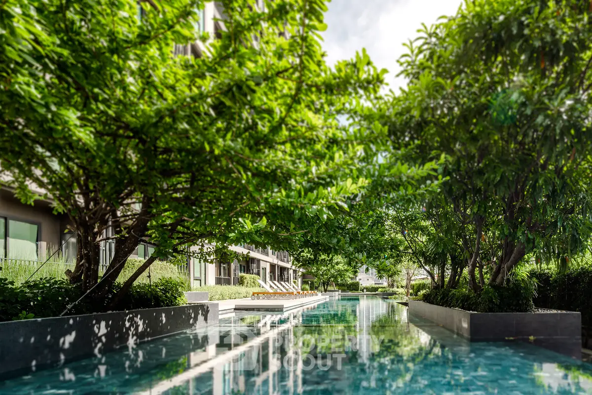 Luxurious residential pool surrounded by lush greenery and modern architecture