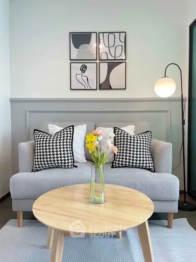 Chic modern living room with stylish sofa, artistic wall decor, and elegant lighting.