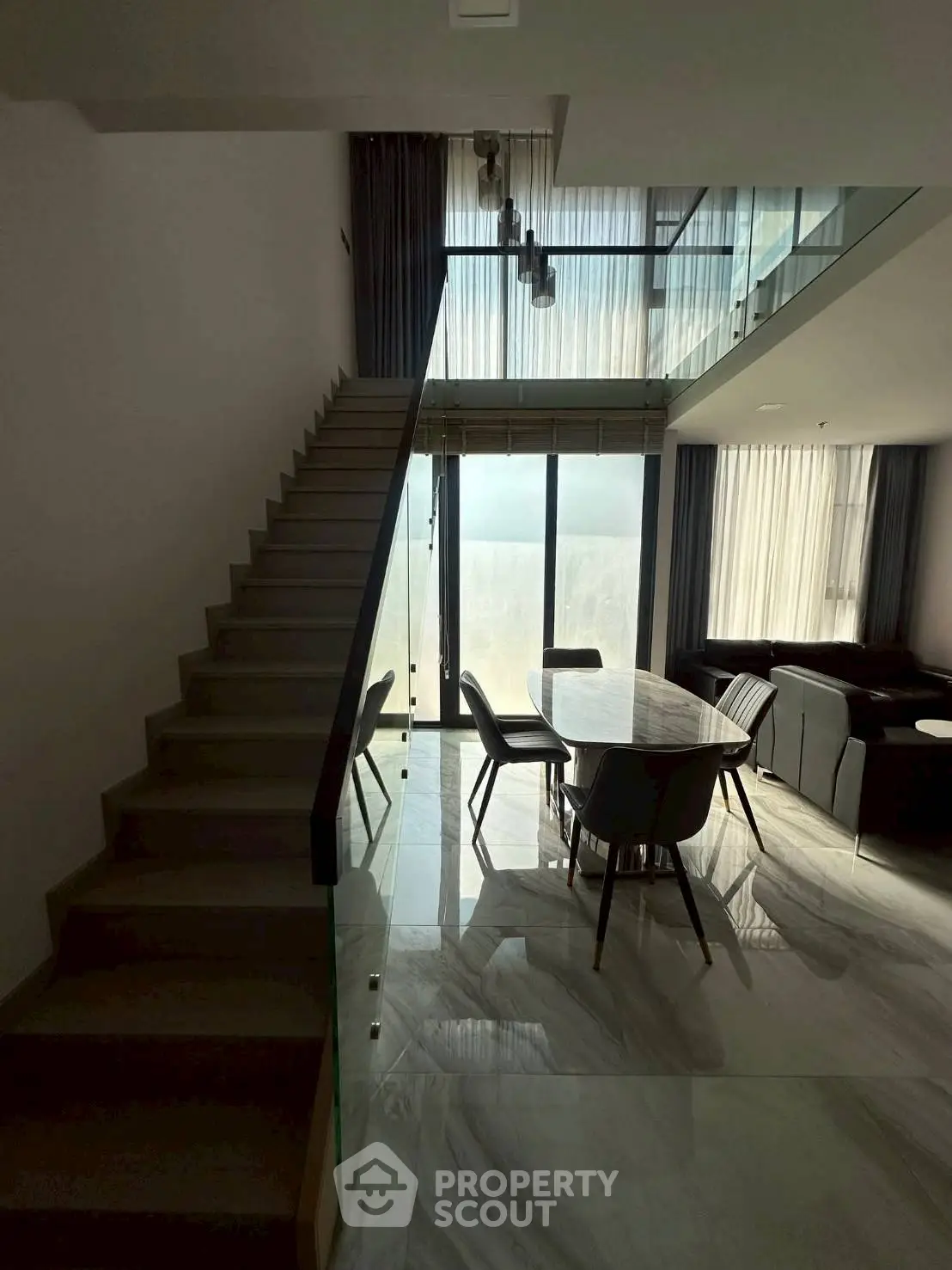 Modern duplex living room with high ceilings and elegant staircase