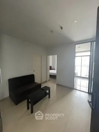 Modern apartment interior with cozy living room and bedroom view, featuring sleek furniture and natural light.