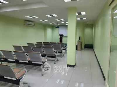 Spacious conference room with modern seating and projector setup, ideal for meetings and presentations.