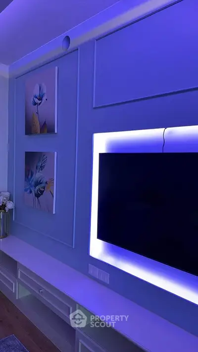 Modern living room with stylish wall decor and ambient lighting around TV