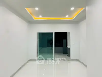 Modern minimalist interior with recessed lighting and sliding glass doors.