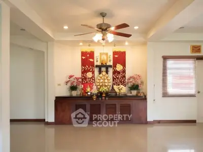 Spacious living room with elegant decor and ceiling fan, perfect for relaxation.