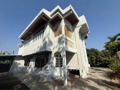 Stunning modern two-story house with unique architectural design and lush surroundings.