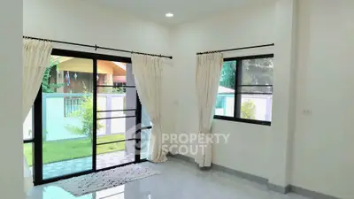 Bright living room with large windows and garden view, perfect for natural light lovers.