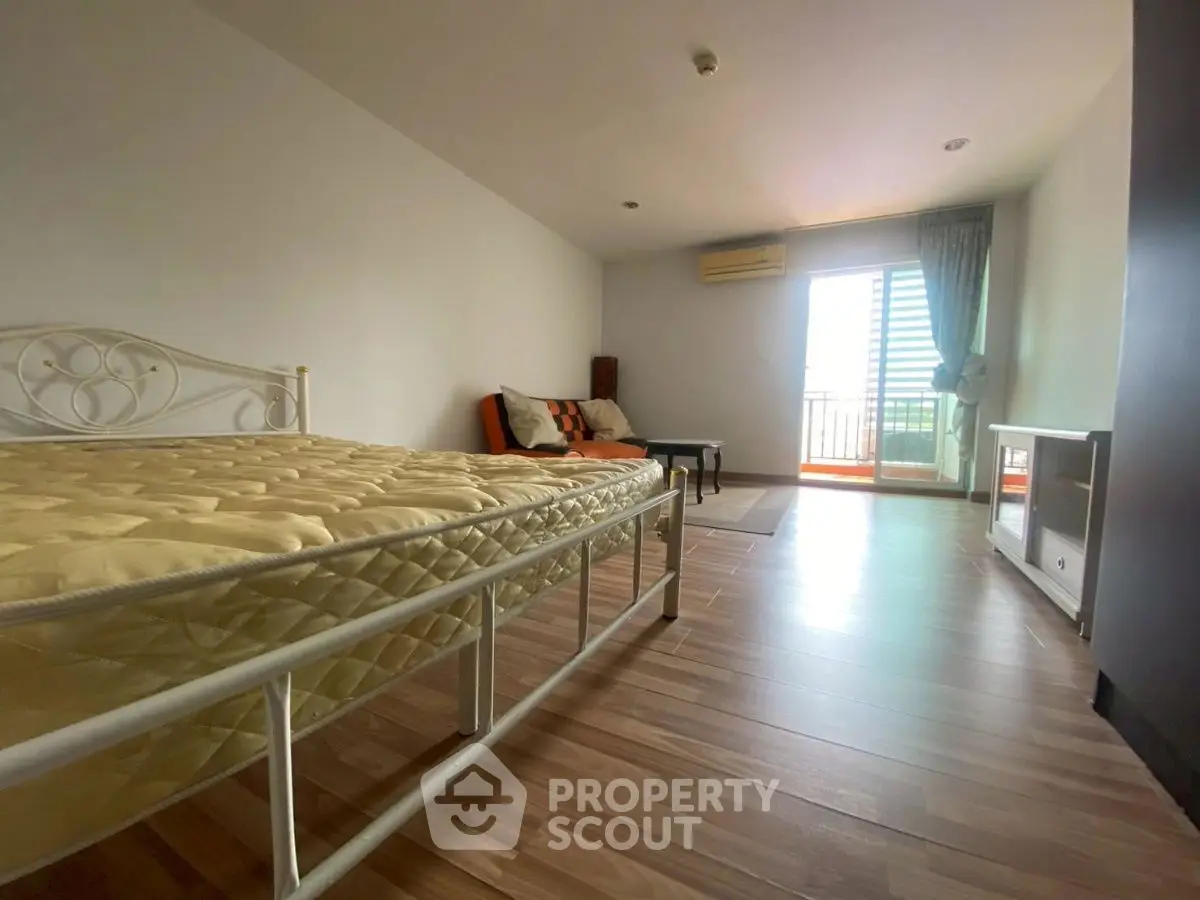 Spacious bedroom with balcony access and modern furnishings