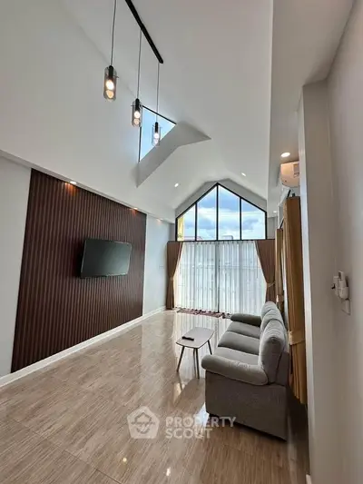Spacious modern living room with high ceilings and large windows offering abundant natural light.
