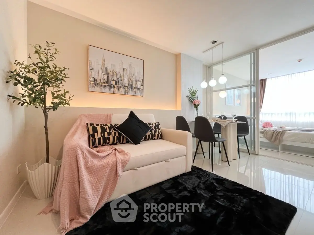 Modern living room with chic decor and dining area in open layout apartment.