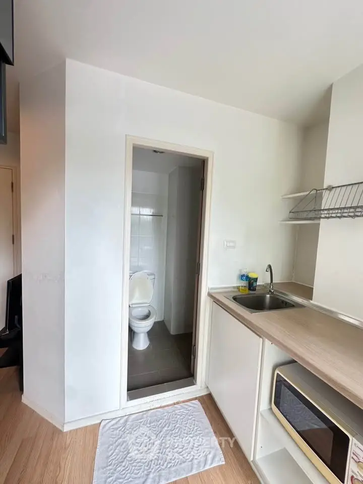 Compact studio apartment with kitchenette and bathroom, ideal for urban living.