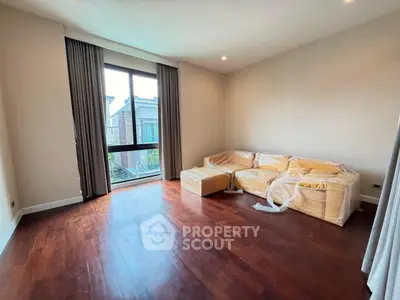 Spacious living room with hardwood floors and large window in modern apartment