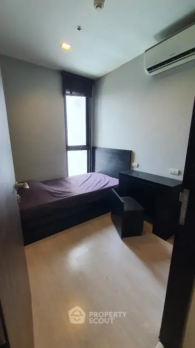 Cozy bedroom with modern furnishings and air conditioning, perfect for a comfortable living experience.