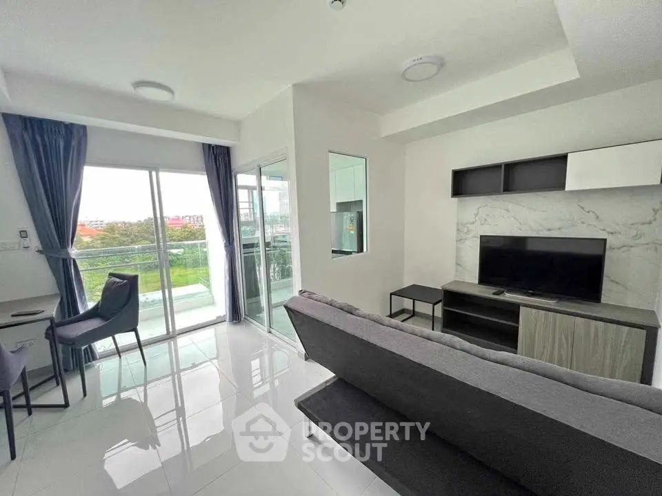 Modern living room with sleek design and balcony view in a contemporary apartment.