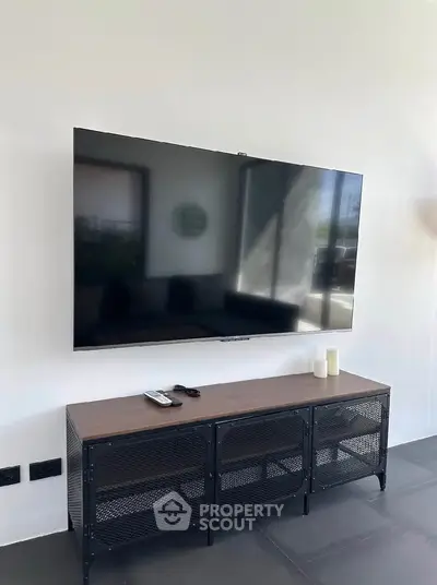 Modern living room with wall-mounted TV and stylish console table, perfect for entertainment.