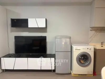 Modern interior with sleek TV unit, fridge, and washing machine in a stylish living space.