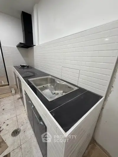 Modern kitchen with sleek black countertop and white subway tile backsplash