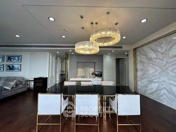 Luxurious dining area with elegant lighting and modern kitchen in upscale apartment.
