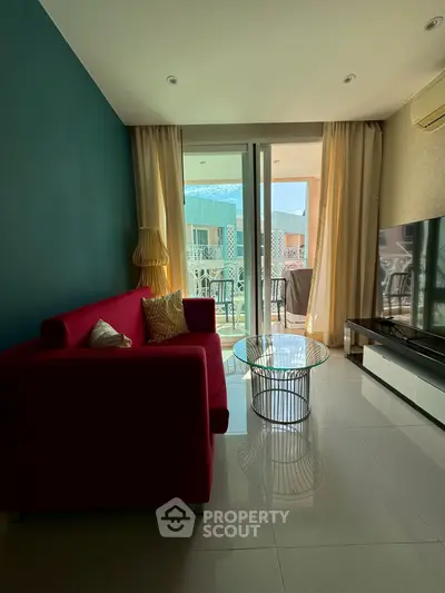 Modern living room with red sofa, glass table, and balcony access in stylish apartment.