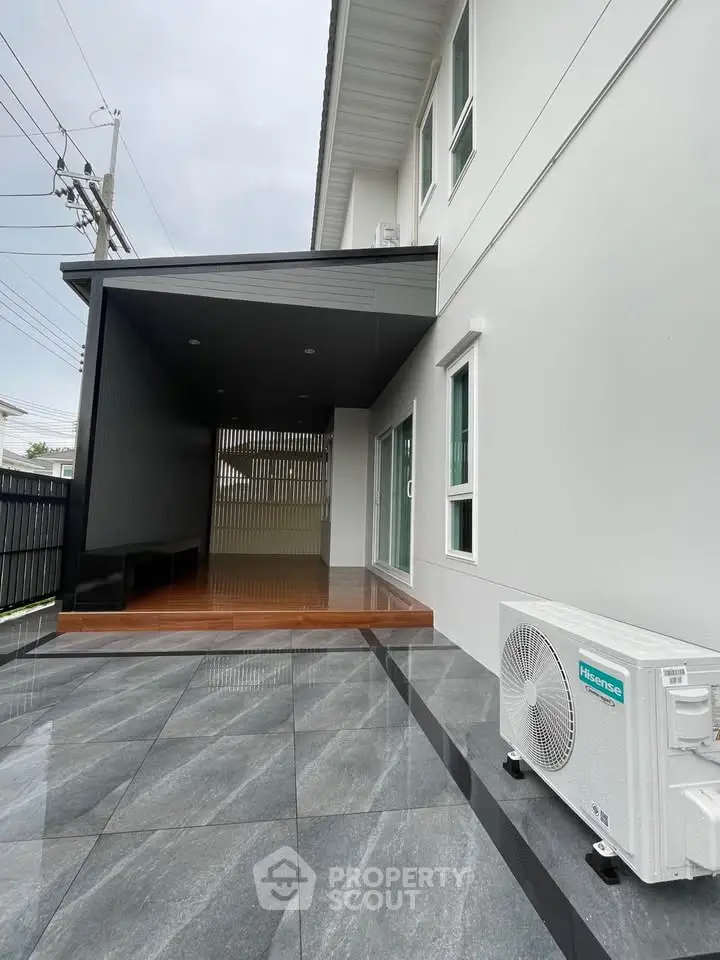 Modern exterior with sleek design and air conditioning unit, featuring polished stone flooring and contemporary architecture.