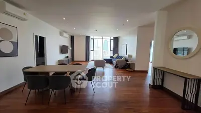 Spacious open-plan living and dining area with modern furnishings and city view.
